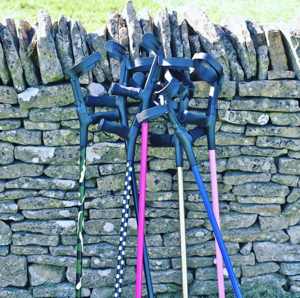 7 pairs of multicoloured cool crutches lean against the wall